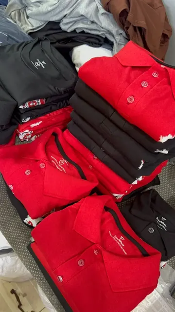 Pilha de polos vermelhas e pretas personalizadas prontas para entrega