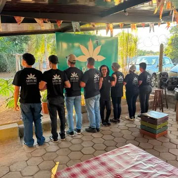 Equipe de costas usando camisetas pretas com a mesma arte