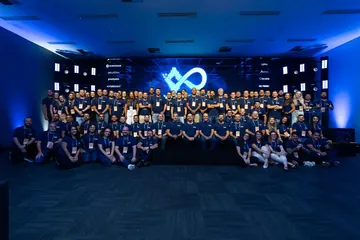 Grupo grande de pessoas em um evento, todas com camisetas azuis personalizadas