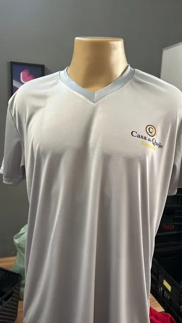 Camiseta gola V cinza-clara com a logo da Casa do Queijo